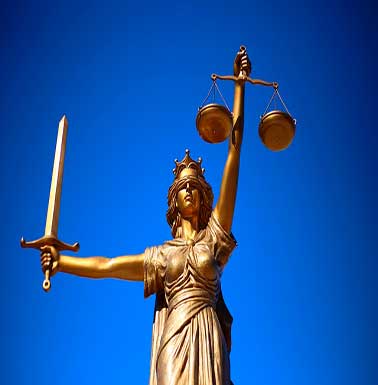 estatua color dorado de mujer con espada y balanza representando la justicia